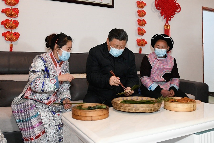 2021年2月3日下午，習(xí)近平在貴州畢節(jié)市黔西縣新仁苗族鄉(xiāng)化屋村苗族村民趙玉學(xué)家，同一家人邊聊家常邊制作當(dāng)?shù)貍鹘y(tǒng)節(jié)日食品黃粑。新華社記者 李學(xué)仁 攝