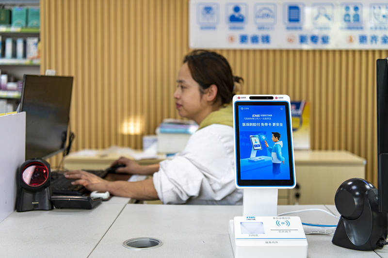 2024年4月10日，浙江金華市區(qū)一家民眾大藥房柜臺上設(shè)置著醫(yī)?！八⒛樦Ц丁睓C(jī)器，群眾看病更加便利。